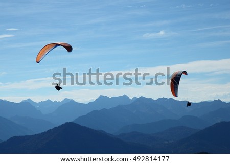 two para-glider flying in blue mountain landscape
