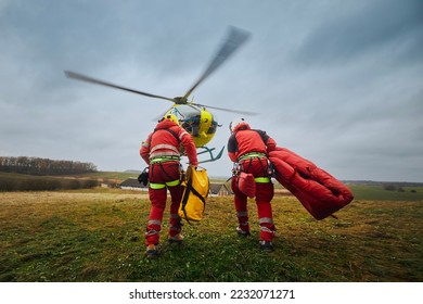 Two paramedic with safety harness and climbing equipment running to helicopter emergency medical service. Themes rescue, help and hope. .
