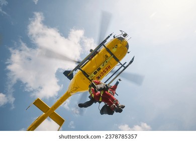 Two paramedics hanging on rope under flying helicopter emergency medical service. Themes rescue, help and heroes.
 - Powered by Shutterstock