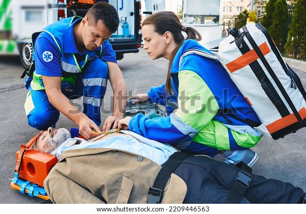 Two Paramedics Helping Injured Patient Lying Stock Photo 2209446563 ...