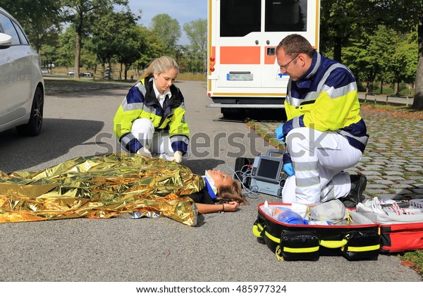 Two\
paramedics helping a woman after a traffic accident\

