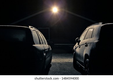 Two Parked Cars In Frosty Night Lit Scene During Winter In Norway