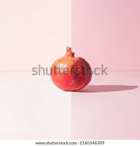 Two parts of one pomegranate, half fresh, half wrinkled. Time and aging concept.