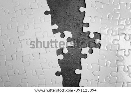 Two parts of white jigsaw puzzle on grey background