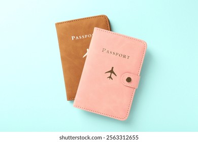 Two passports in bright covers on turquoise background, top view