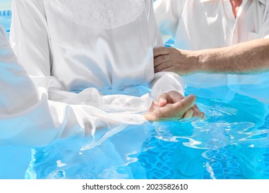 Two pastors baptize a women in the name of Christ