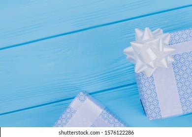 Two patterned gift boxes for birthday. Copyspace. Blue wood background.