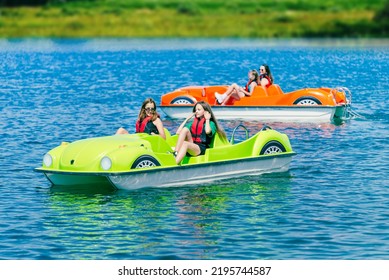 Two pedal boats on a mountain lake with teenagers
