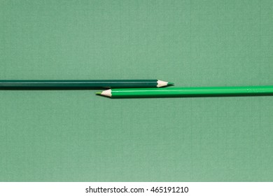 Two pencils of different shades of green.