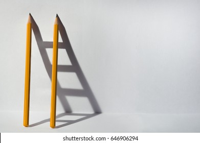 Two pencils and a shadow in form of ladder. Success, teamwork and solving problems business concept. Copy space for text . - Shutterstock ID 646906294