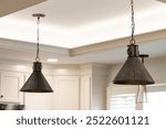 Two Pendant Lights Hanging From The Kitchen Ceiling