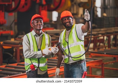 Two People Black Man African American Worker Control Heavy Machine In The Factory.