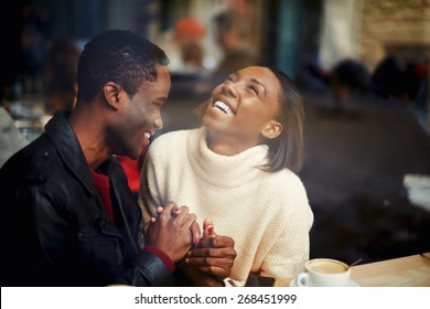 Two people in cafe enjoying the time spending with each other, happy stylish friends having coffee together, laughing young couple in cafe, having a great time together, view through cafe window