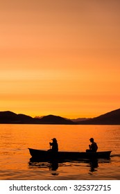 Two people canoe across Whitefish Lake in the sunset in Whitefish, MT.