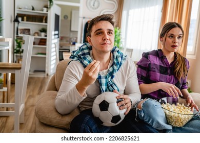 Two People Couple Man And Woman Boyfriend And Girlfriend Or Husband And Wife Sitting On The Sofa At Home Watching Football Soccer Game Cheering Copy Space Tense Anticipation