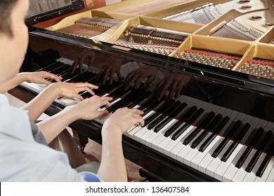 Two People, A Couple Playing Piano Duet, Showing Mostly Their Hands