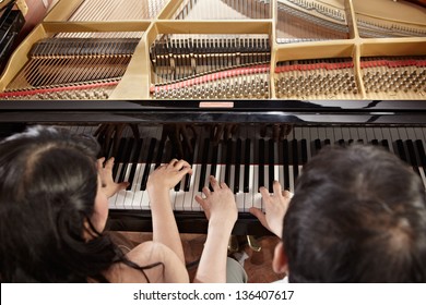 Two People, A Couple Playing Piano Duet, Showing Mostly Their Hands