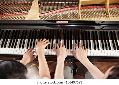 Two People, A Couple Playing Piano Duet, Showing Mostly Their Hands