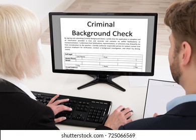 Two People Doing Criminal Background Check On Computer