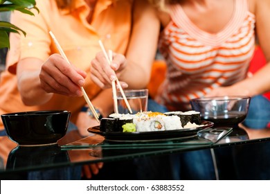 Two people eating sushi at home- FOCUS is on the sushi plate