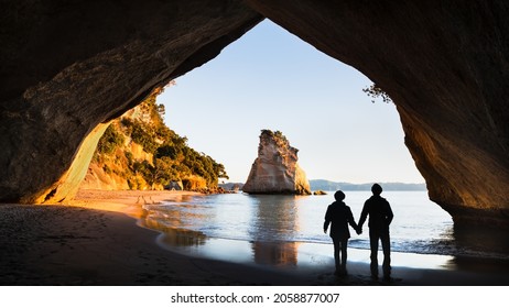 Two people enjoying the view of the Cathedral Cove at sunrise, Coromandel Peninsula, North Island, New Zealand - Powered by Shutterstock