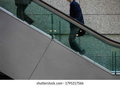 Two People Going Up Escalator