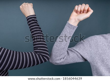 two people greeting each other with elbows