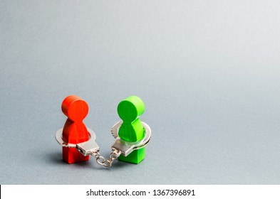 Two People Are Handcuffed. Unbreakable Bond. Strong Trusting Relationships And Reliable Partners. Business Deal Concept. Transaction. Support. Wooden Figures Of People. Prisoners