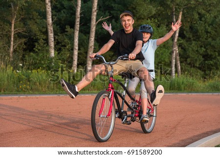 Two people happily riding a tandem bike.