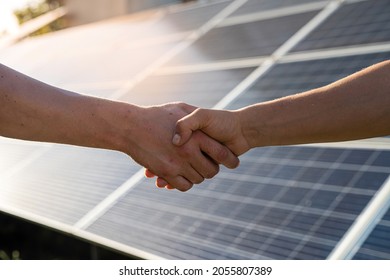 Two People Having A Shaking Hands Against Solar Panel  After The Conclusion Of The Agreement In The Renewable Energy  