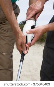 Two people holding a golf club
