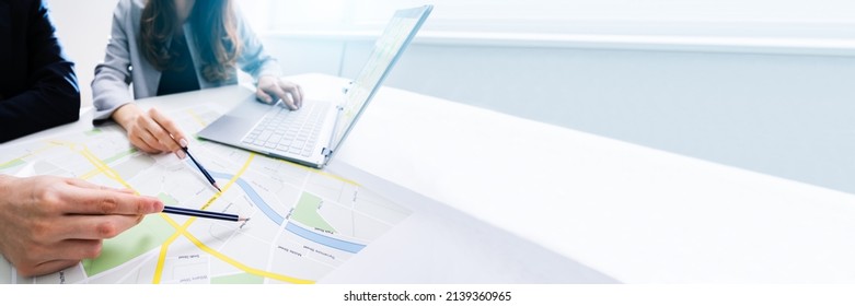 Two People Looking At City Map With Laptop At Table