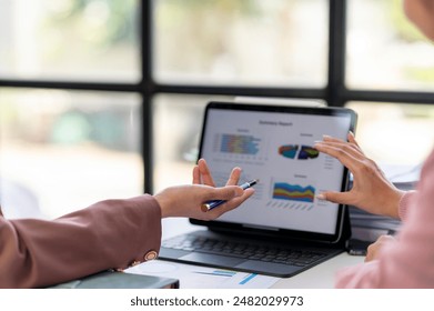 Two people are looking at a computer screen with a lot of graphs and charts. They are discussing the data and trying to understand the information
