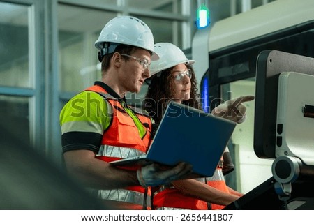 Two people are looking at a laptop computer. Concept of Industry 4.0 with diverse engineers collaborating on automation technology.