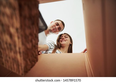 Two People Looks Down Into The Box. Conception Of Moving.