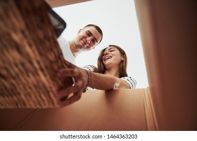 Two People Looks Down Into The Box. Conception Of Moving.