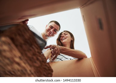 Two People Looks Down Into The Box. Conception Of Moving.