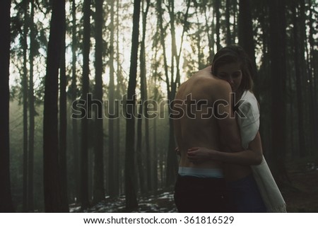 Two people in love in the embrace of dark magick forest