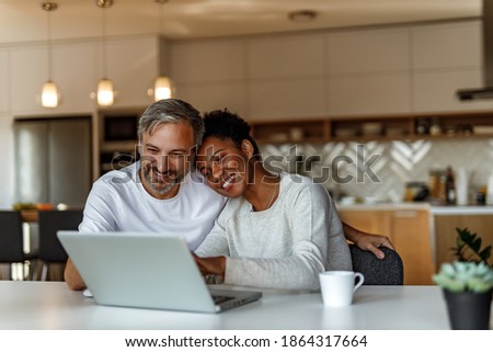 Two people in love together looking for something online.