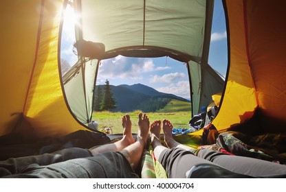 Two people lying in  tent with a view of mountains. Carpathians, Ukraine