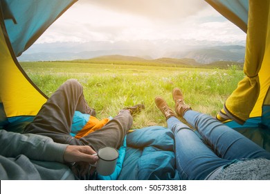 Two people lying in tent with a view of mountains. Altay, Russia.