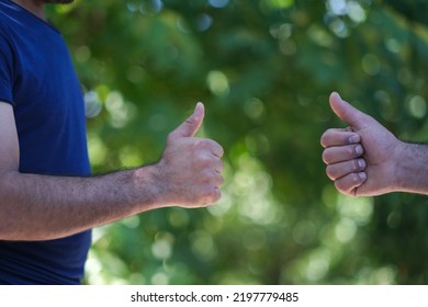 Two People Making Hand Sign Thumbs Up And Thumbs Down, Yes Or No, Like Or Dislike Concept