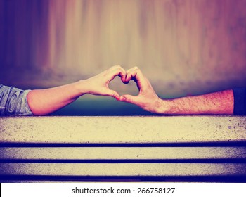  Two People Making A Heart Shape With Their Hands On A Bench Toned With A Retro Vintage Instagram Filter  App Or Action (shallow Depth Of Field On The Thumbs)
