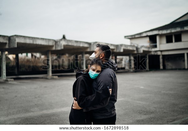 Two people in masks hugging.Couple being\
divided by incurable infectious disease.Infection\
control,isolation.Loved one illness.Saying goodbye.Farewell.Letting\
go.Toxic relationship.