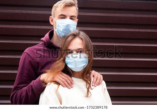 Two people in masks hugging.Couple\
being divided by incurable infectious\
disease