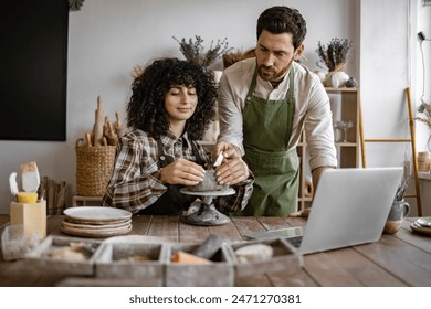 Two people in a pottery workshop crafting ceramic piece together. Collaborative art creation in relaxed and creative environment. - Powered by Shutterstock