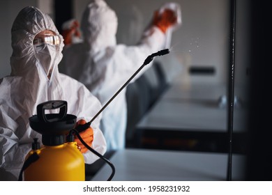 Two people in protective gear cleaning the glass walls - Powered by Shutterstock