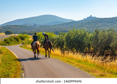 Two People Riding Horses In Tuscany Countryside, Italy.