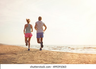 Two People Running On The Beach