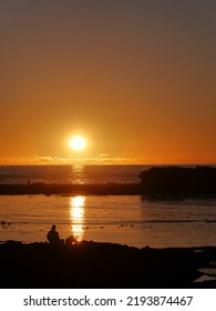 Two People Sitting On Beach As The Sun Sets, Essaouira, Morocco